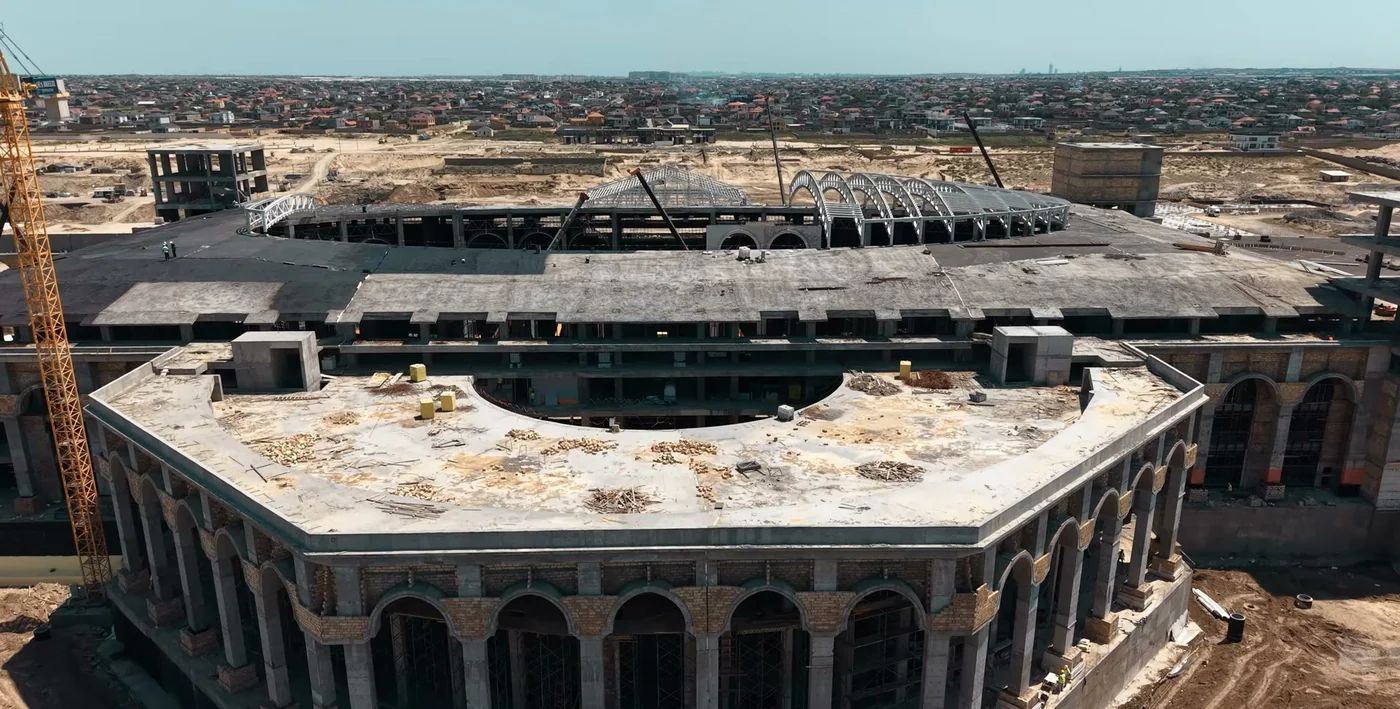 The frame with a colonnade and roof, cranes on site