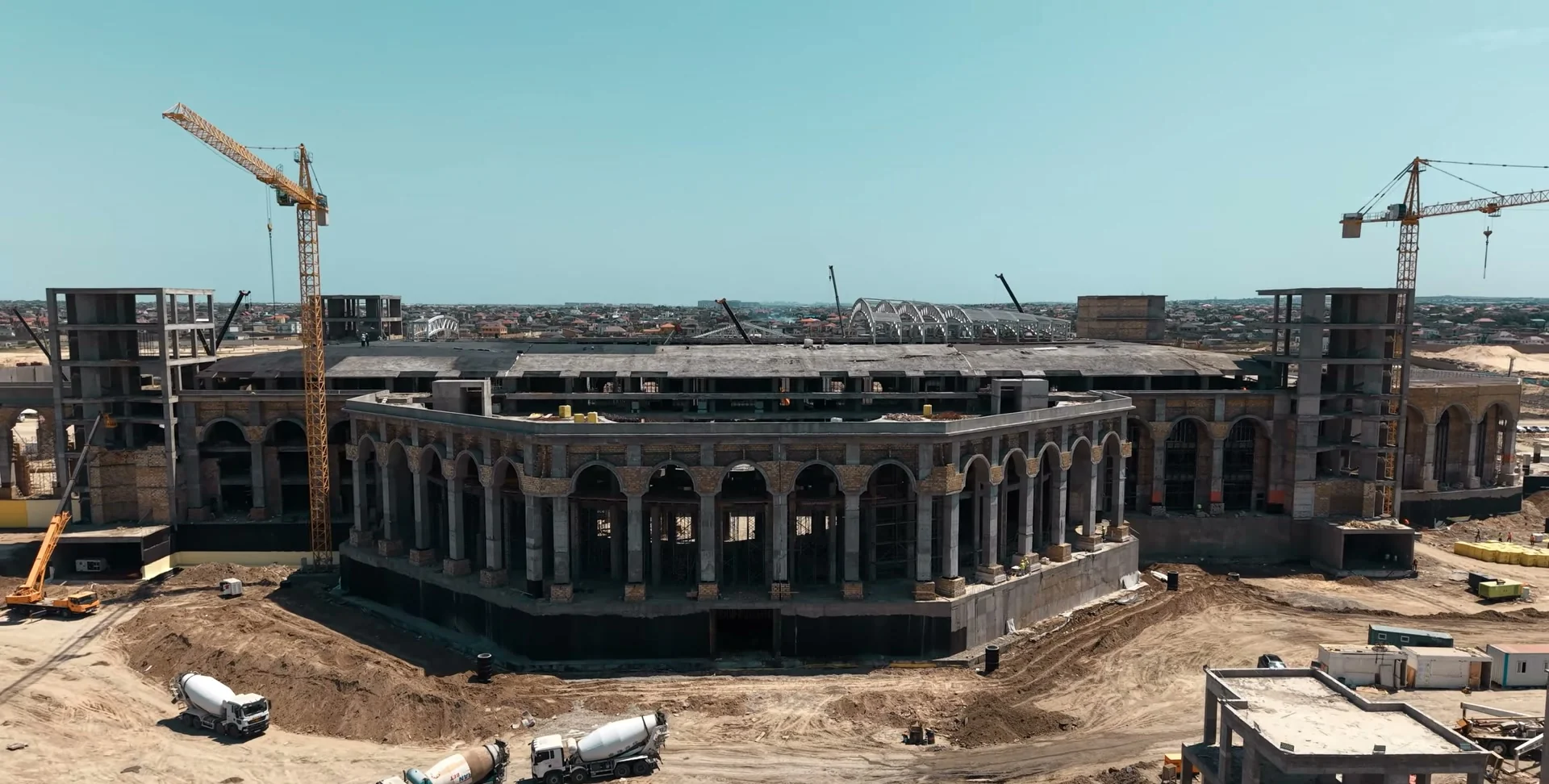 The colonnaded facade: tower cranes and concrete mixers