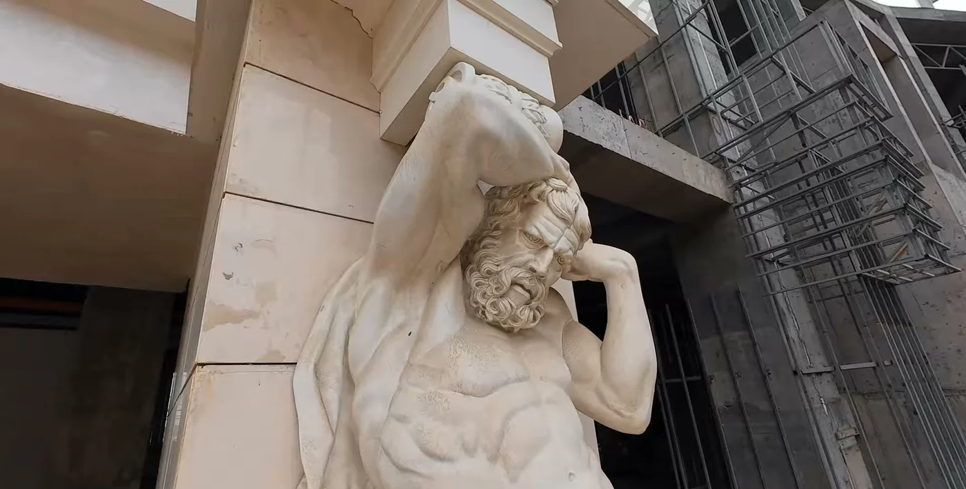 A stone atlas figure on the facade in scaffolding