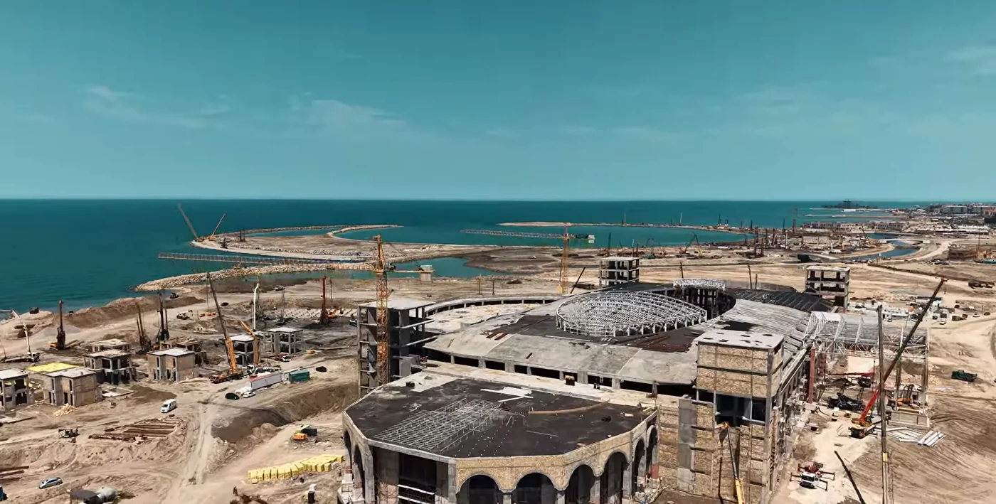 The building from the sea side: a dark roof and a foundation pit